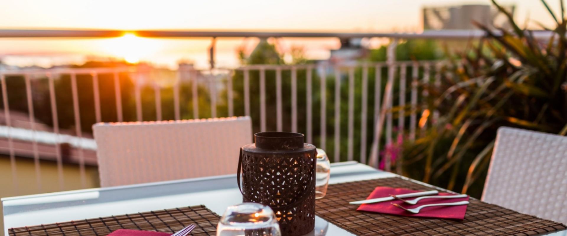 Cena romantica al tramonto su una terrazza elegante.