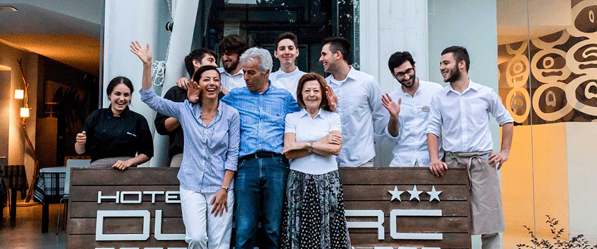 Gruppo di persone sorridenti davanti all'Hotel Duca, atmosfera amichevole e accogliente.